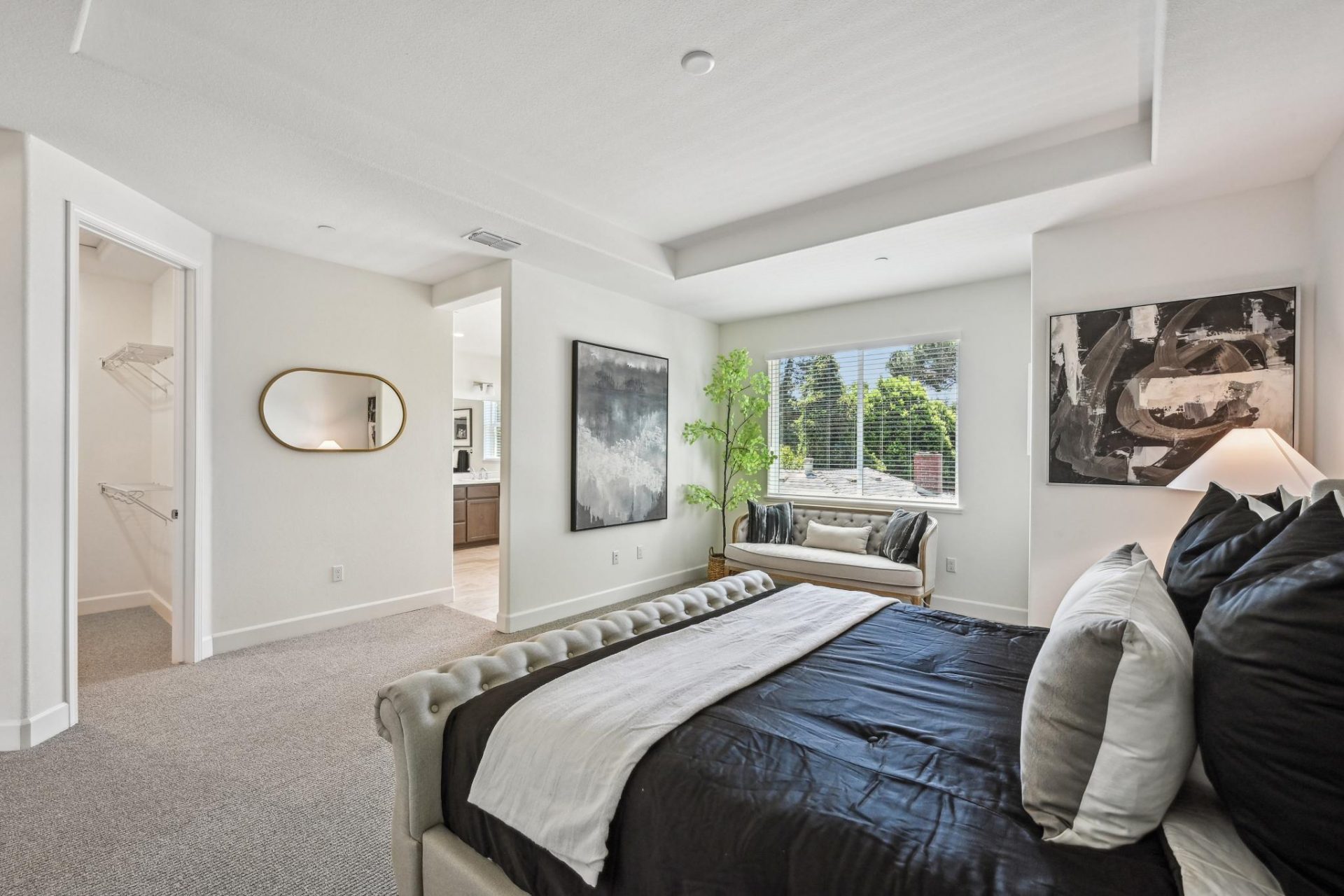 Carpeted bedroom with 9 foot recessed ceiling and canned lights, large window, 8 foot doors to the tiled bathroom and carpeted walk-in closet.