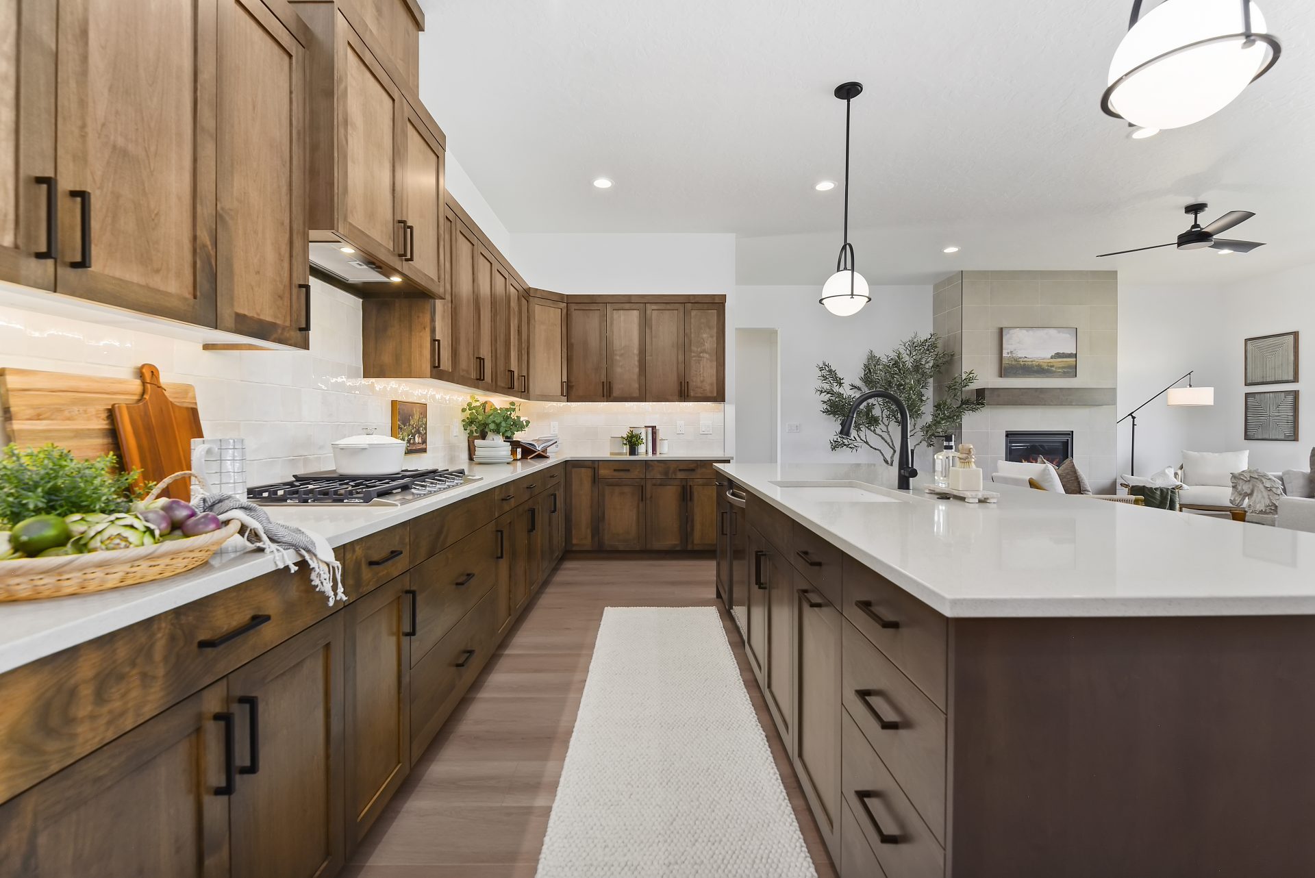 Chef's kitchen with dark beech wood cabinets, black fixtures, large island, white quartz countertops, 9 foot ceilings and canned lighting.