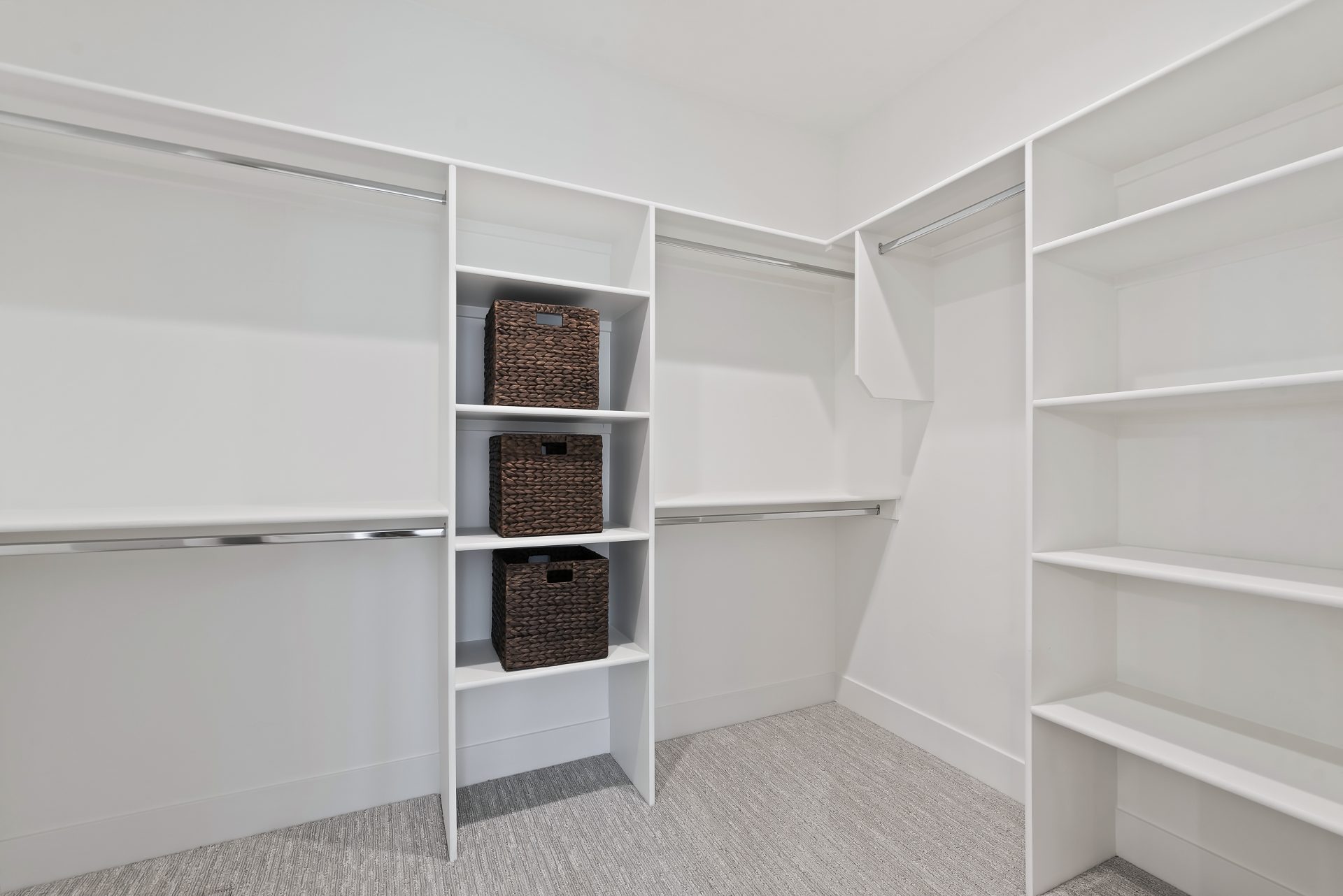A large closet space with multiple hanging rods and shelves.