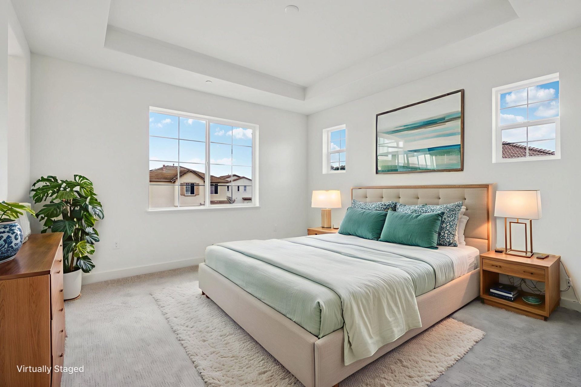 Carpeted bedroom with a tray ceiling and two windows letting in natural light. Carpeted bedroom with a tray ceiling and two windows letting in natural light. The room features an upholstered bed with green and white bedding, flanked by wood nightstands wi